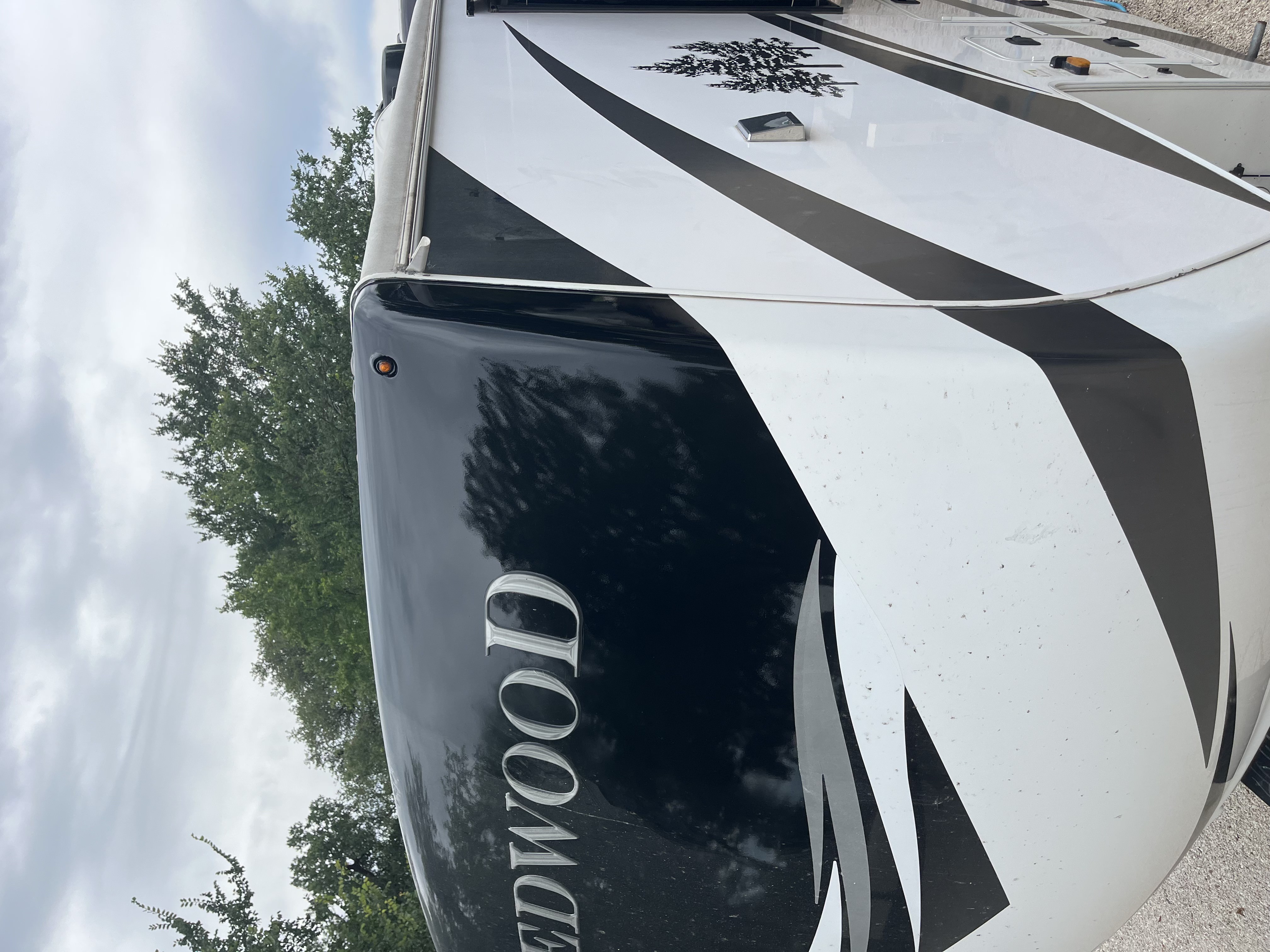 RV front cap corner after fiberglass repair and paint — smooth black-painted finished surface showing complete repair of the previously damaged corner — Boss Bull Mobile RV Services
