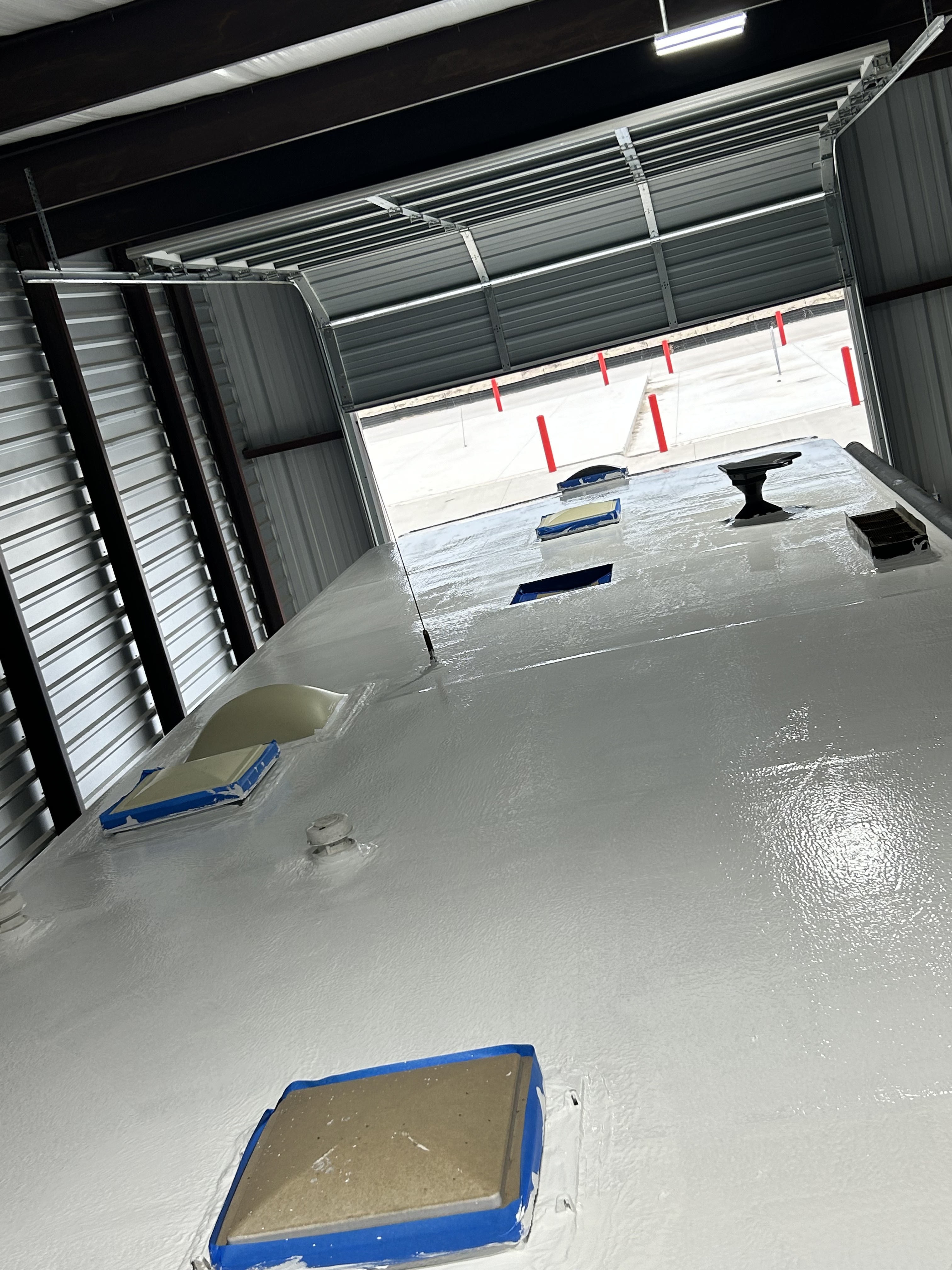 Close overhead view of a Coachmen Freelander RV roof after complete elastomeric restoration — white coat fully cured with a smooth wet-look sheen, all penetrations sealed — Boss Bull Mobile RV Services