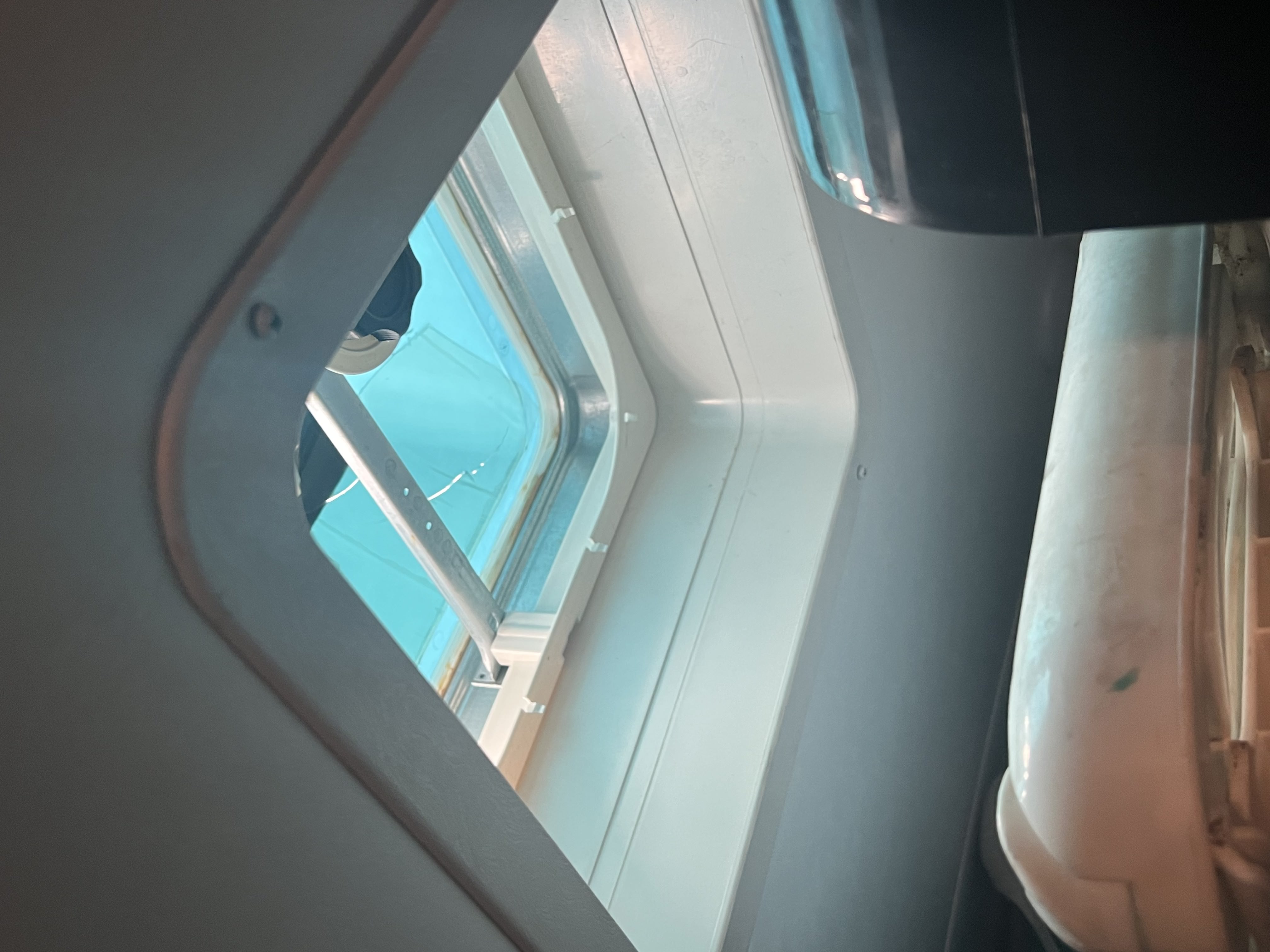 Cracked RV skylight dome viewed from inside — hail impact opened a gap in the acrylic — Boss Bull Mobile RV Services