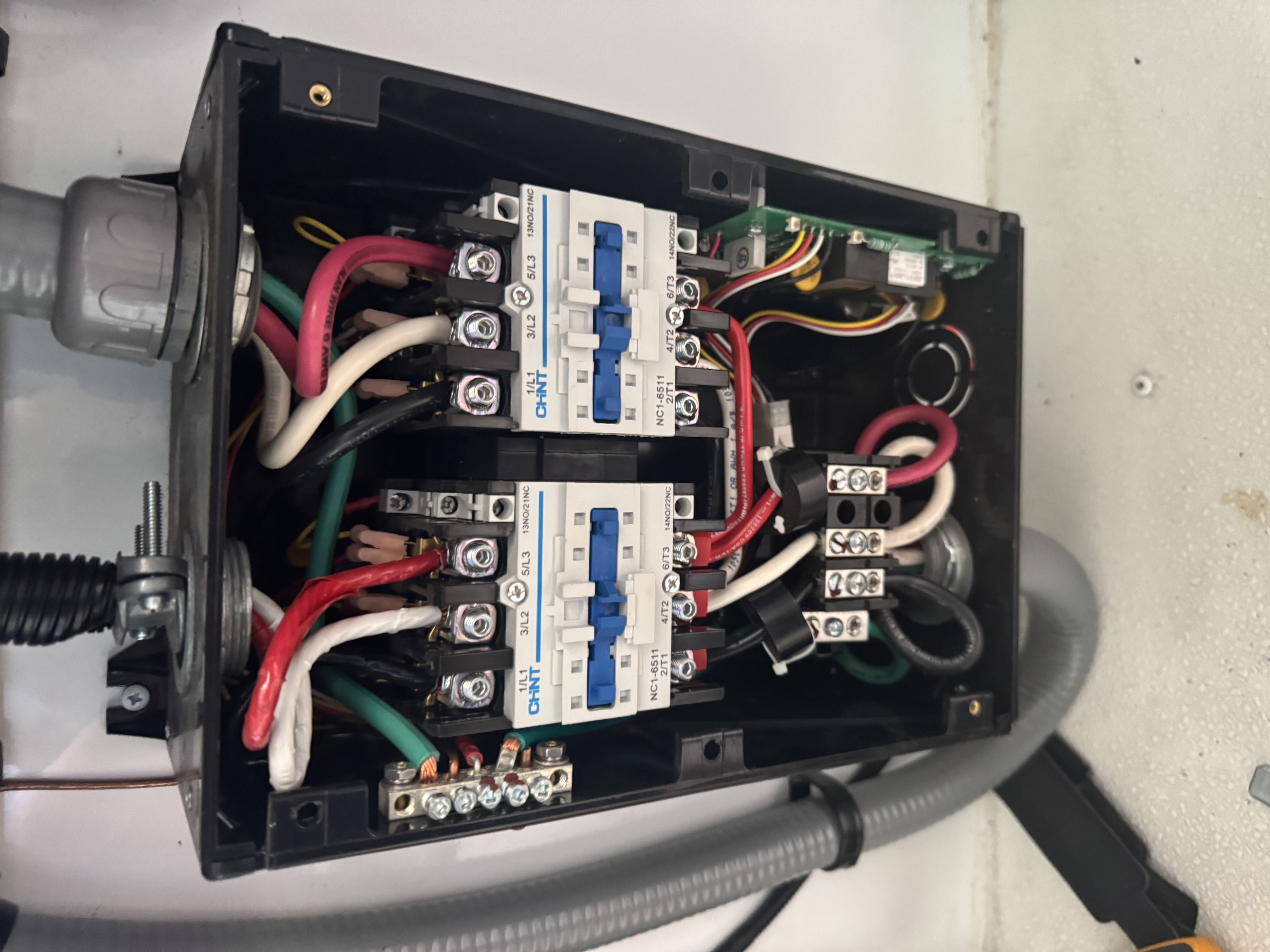 Open RV electrical enclosure showing two CHNT NC1-6511 transfer switch contactors wired with multi-color conductors and a control board — diagnostic documentation — Boss Bull Mobile RV Services
